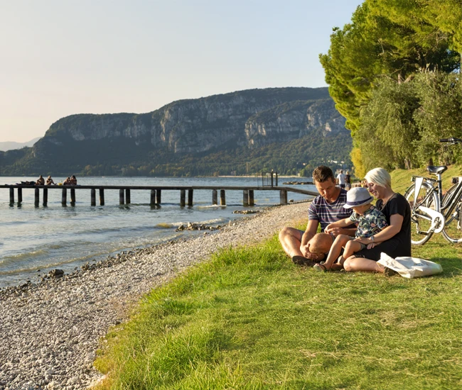 famiglia adagiata sulla spiaggia del campeggio La Rocca a Bardolino