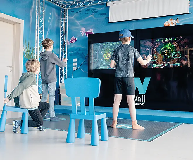 bambini che giocano con video giochi interattivi con ledwall al mini club la rocca camping